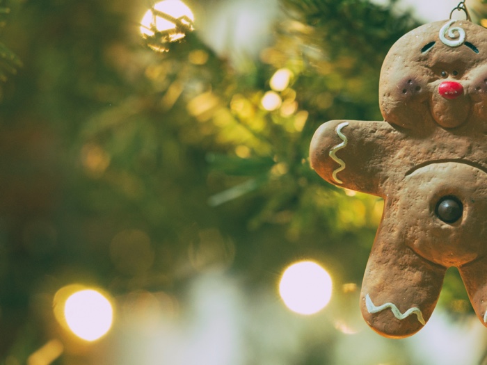gingerbread man ornament with christmas tree lights blurred in background