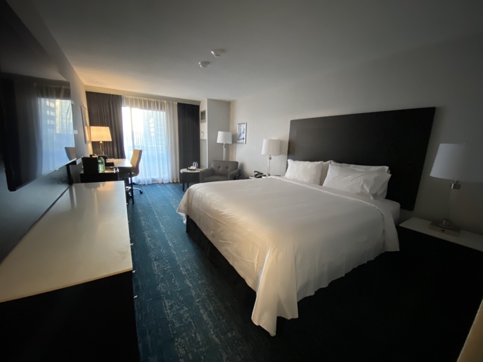 chelsea hotel guest room 2025 - Ottawa Road Trips guest room with king sized bed, desk, grey chair, lots of lamps, marble-topped dresser