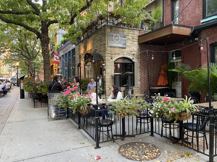 donatello restaurant toronto patio - Ottawa Road Trips restaurant sidewalk patio beside a brick building, with flower baskets and shaded by large trees