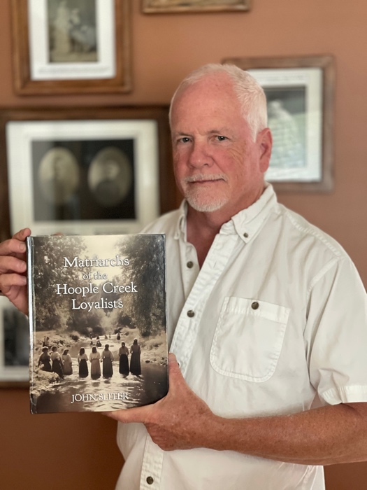 john sliter photo sized - Ottawa Road Trips man with white hair holding copy of book called matriarchs of the hoople creek loyalists
