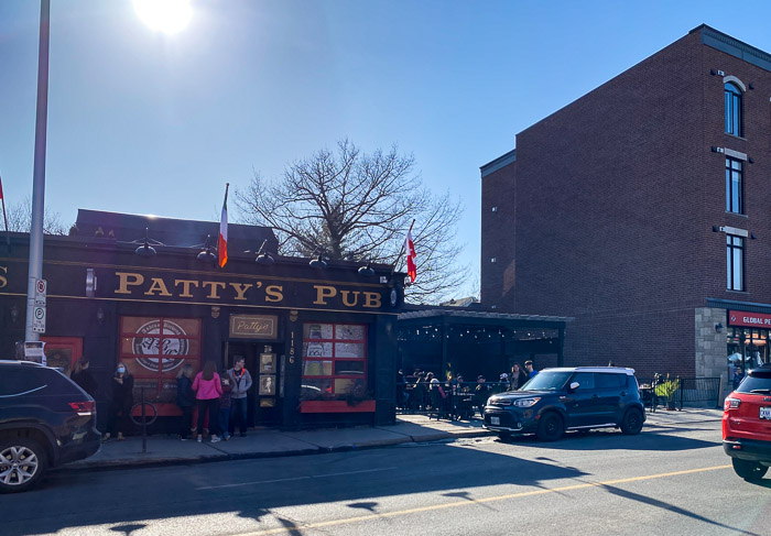 exterior of patty's Pub with gold sign and flags