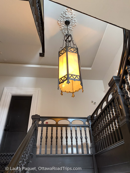 frontenac club staircase - Ottawa Road Trips wooden staircase with carved spindles, and a vintage chandelier hanging from a plaster ceiling medallion
