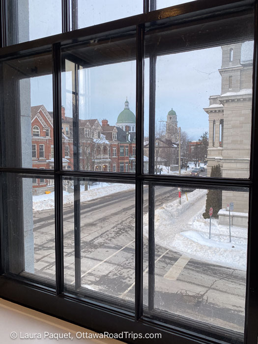 frontenac suite window - Ottawa Road Trips view of brick heritage homes and a domed church through a mullioned window