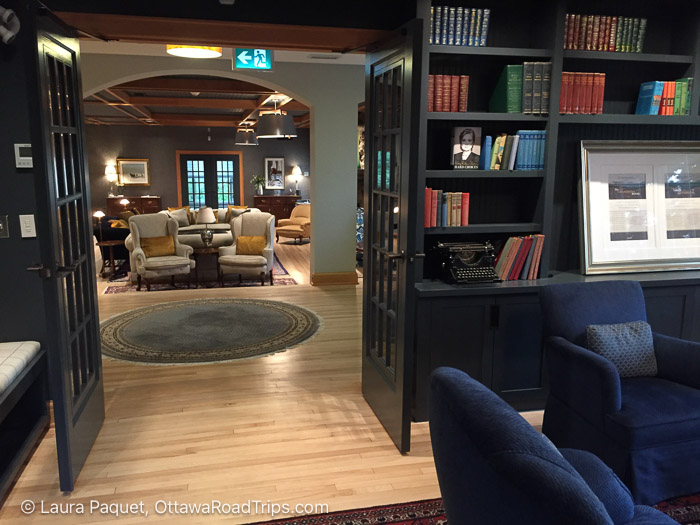 obrien house living room - Ottawa Road Trips library with blue armchairs in foreground, with french doors opening to large living room beyond