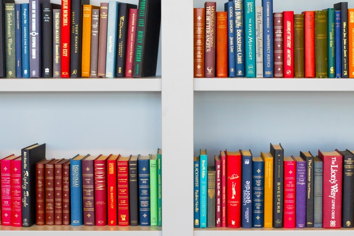 multicoloured books on white shelves