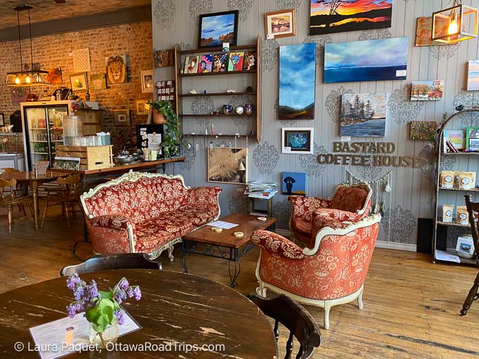 coffee shop interior with antique sofa and chairs, artwork on walls, exposed brick wall