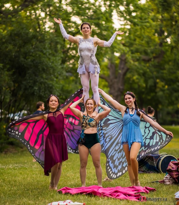 four young women in fairy costumes, with one woman standing on the shoulders of another