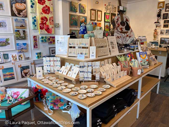 art gallery with paintings on walls and shelves of jewellery and purses at the hive in bath, ontario