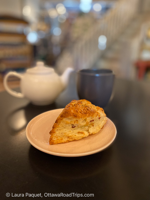 scone on a white plate with teapot and mug in background at ellena's in Napanee