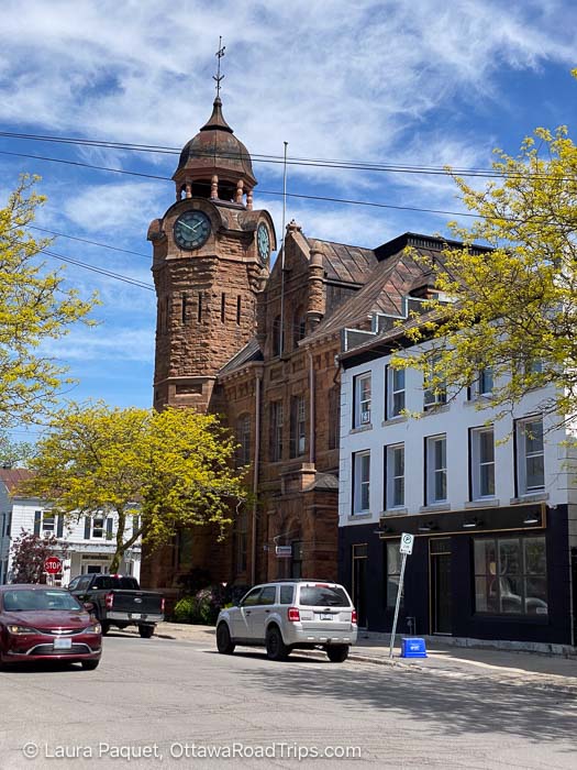 red sandstone building with a clock tower topped with a cupola