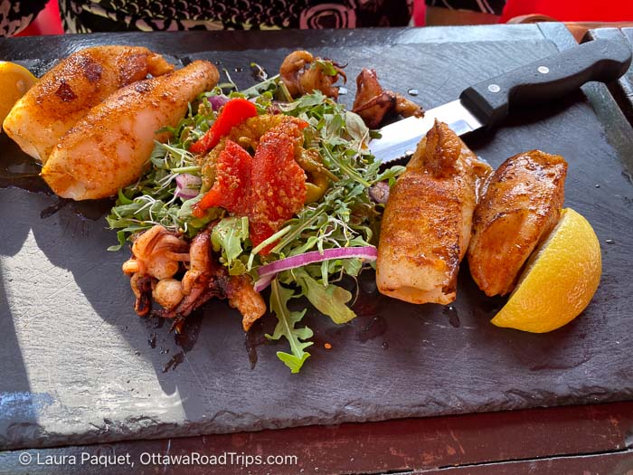 calamari with salad and lemon on a stone platter