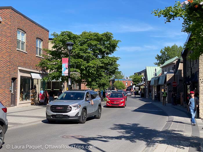 curving rue sainte-anne lined with small buildings housing shops and restaurants in sainte-anne-de-bellevue, quebec