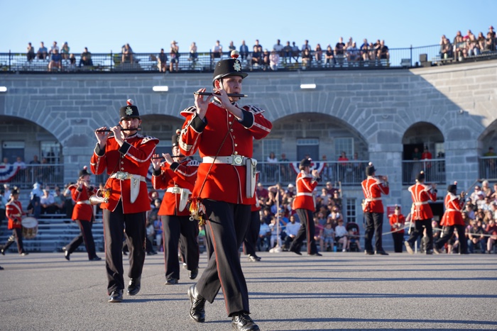 soldiers in red jackets and black jackets playing flutes while marching