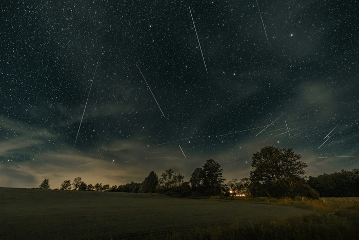 clay-banks-perseid-unsplash - Ottawa Road Trips traces of meteors in a dark sky above an illuminated farmhouse