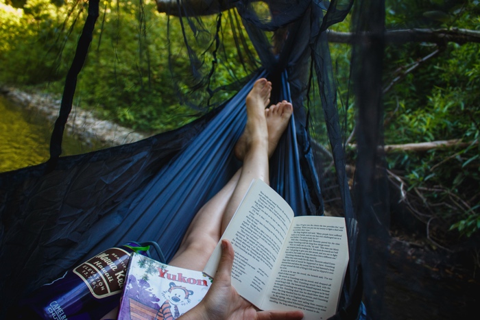 katya-ross-reading-book-hammock-unsplash - Ottawa Road Trips someone reading a book in a hammock, photographed from behind