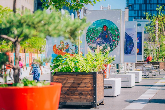 indigenous artworks displayed on large outdoor banners on ste. catherine street in montreal.