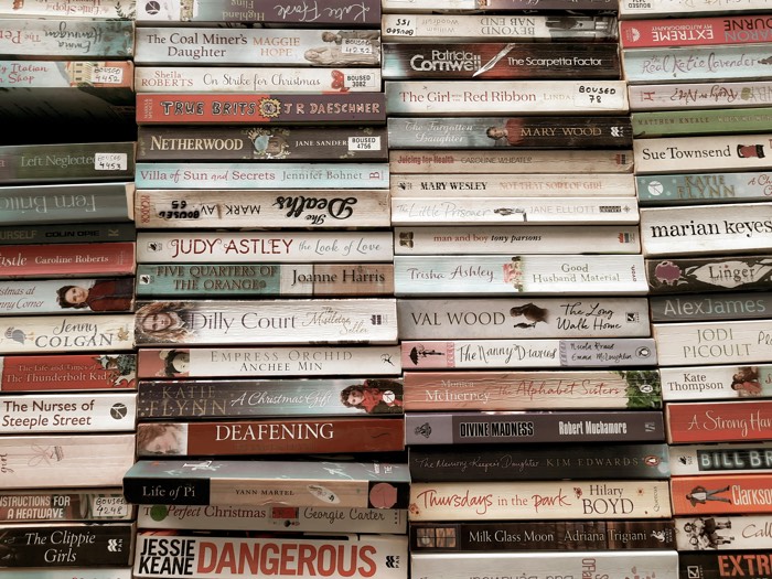 urja-bhatt-used books paperbacks-unsplash - Ottawa Road Trips stacks of mass market paperbacks on a shelf
