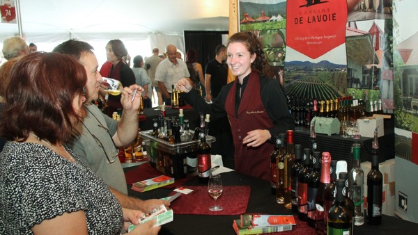 woman pouring wine surrounded by a crowd