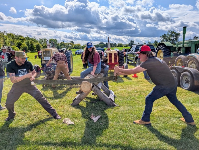 gpm crosscut saw at fall festival 2025 700 - Ottawa Road Trips two men cutting a log with a crosscut saw outdoors with spectators